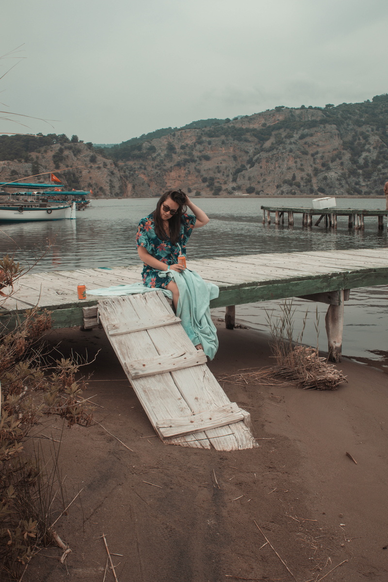 long hair, turkey, young women, waterfront, wood, looking at camera, nautical vessel, nature, sitting, outdoors, pier, day, watercraft, dock, mountain
