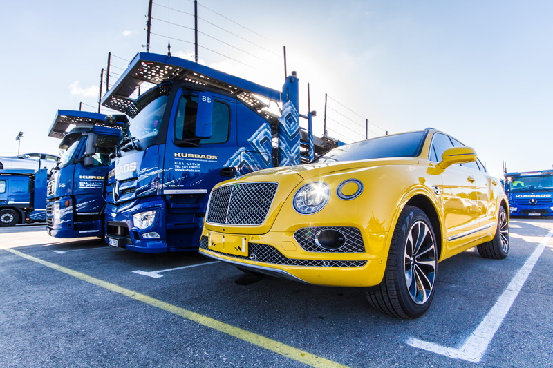 land vehicle, beside, road marking, parked, vehicles, yellow, day, daytime, automobile, trucks, modern, luxury, mode of transportation, wheels, city, marking