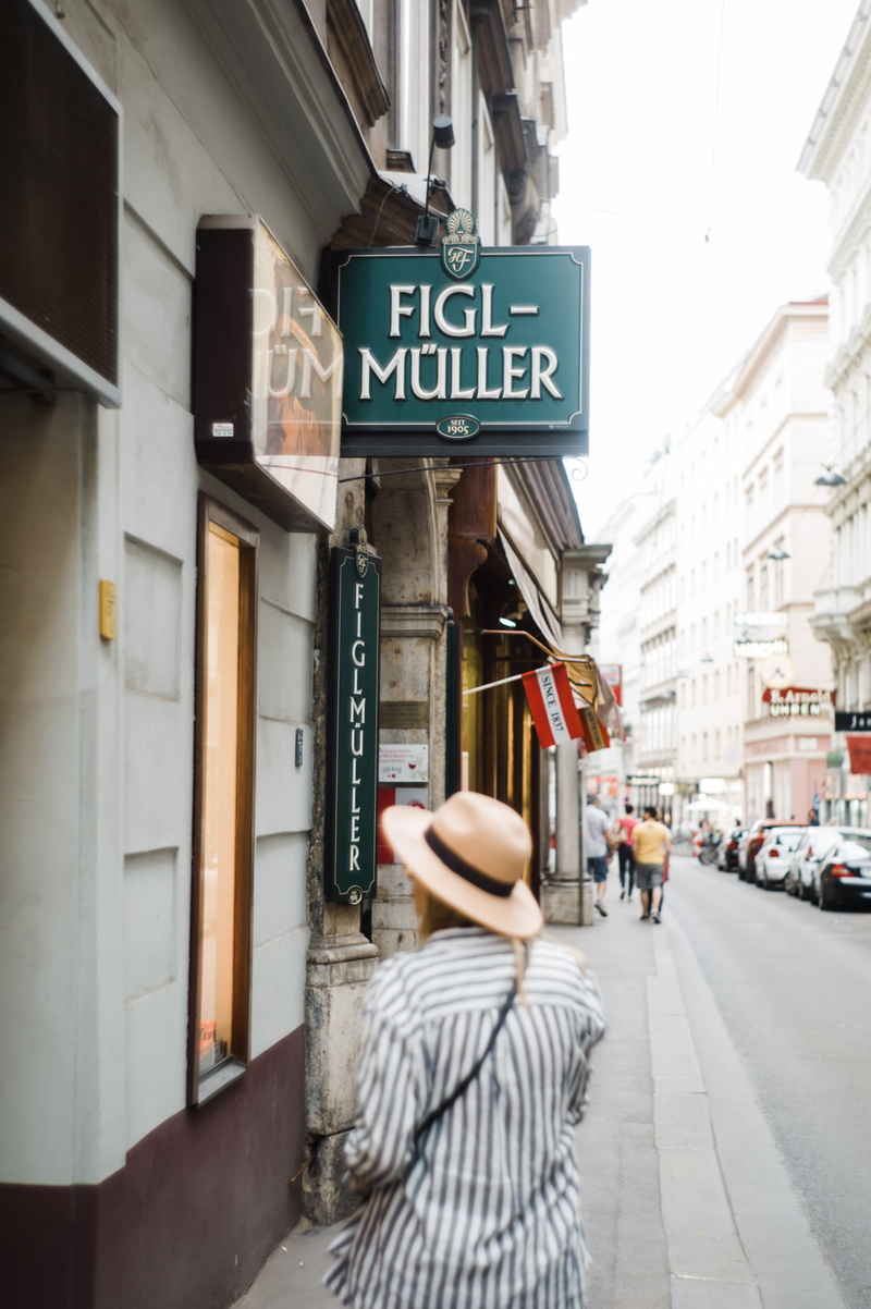 building, day, sign, commercial sign, street, information, building exterior, western script, one person, outdoors, city, walking, real people, woman, muller