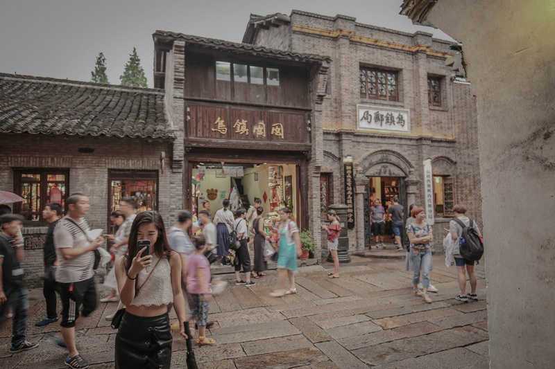 wuzhenzhen, large group of people, men, architecture, group of people, communication, street, standing, built structure, women, 2K, crowd, adult, day