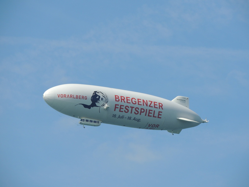 single object, sky, white color, blue, germany, side view, zeppelin, airplane, motion, transportation, lake, mode of transportation, clear sky, flying