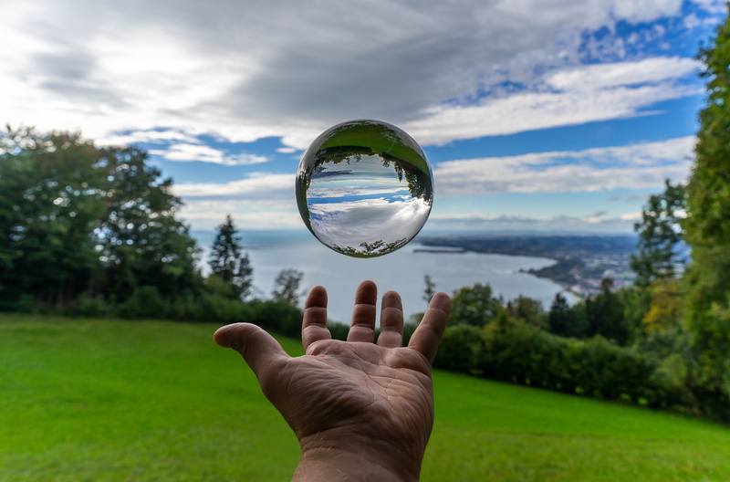 nature, outdoors, glass ball, unrecognizable person, landscape, scenic, sphere, crystal ball, human finger, holding, travel, human hand, bregenz, focus on foreground