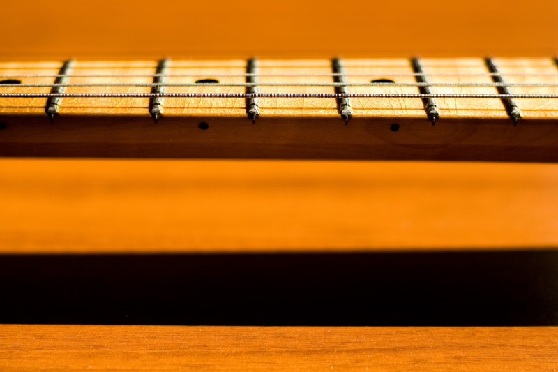musical instrument, string instrument, studio shot, Bass, selective focus, black color, colored background, old, extreme close-up, wood - material, Guitar