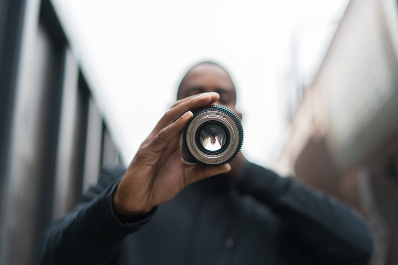 human body part, finger, one person, black man, day, shallow, photographer, holding, blurry, united states, prime lens, camera - photographic equipment