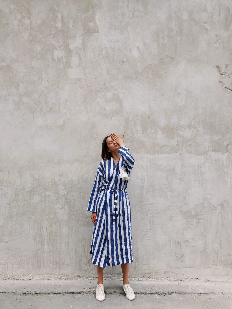 real people, standing, young adult, wall, women, profile view, person, one person, holding, woman, young women, daylight, clothing, wall - building feature