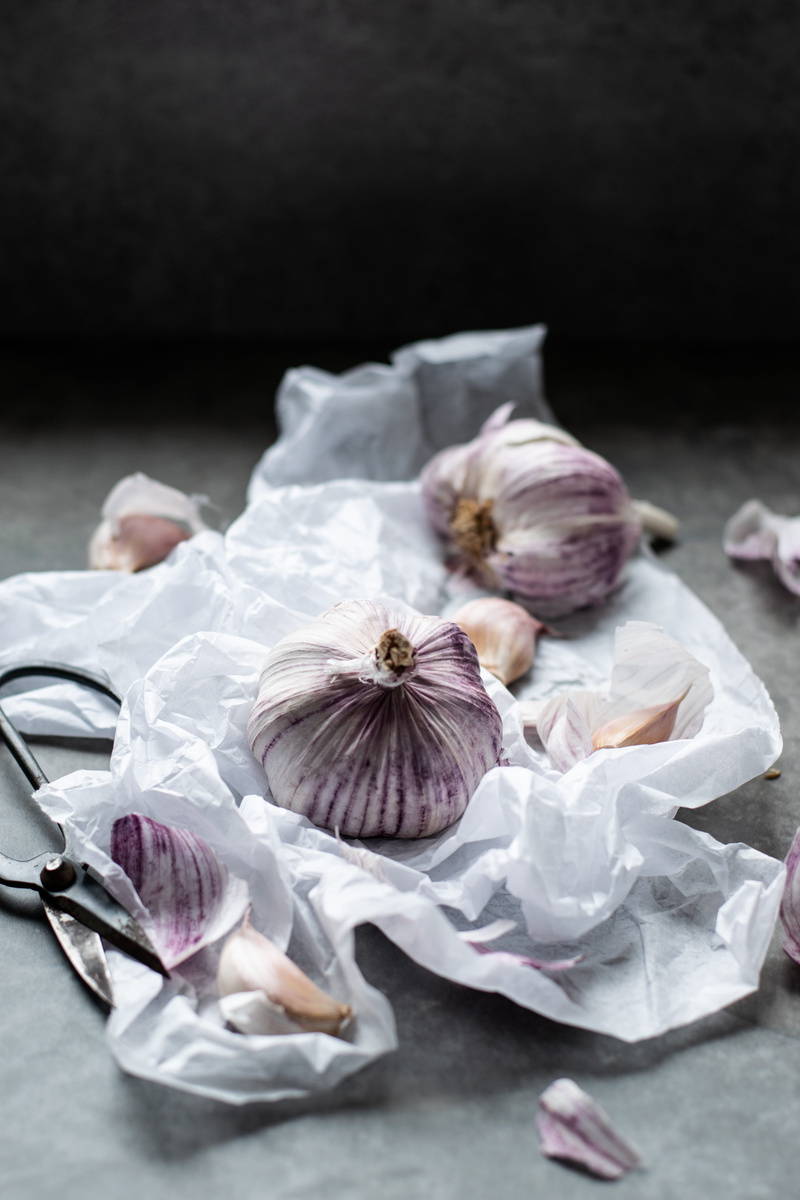 crumpled paper, food, photography, 5K, healthy eating, paper, red, focus on foreground, garlic bulb, crumpled, plastic bag, black background, close-up