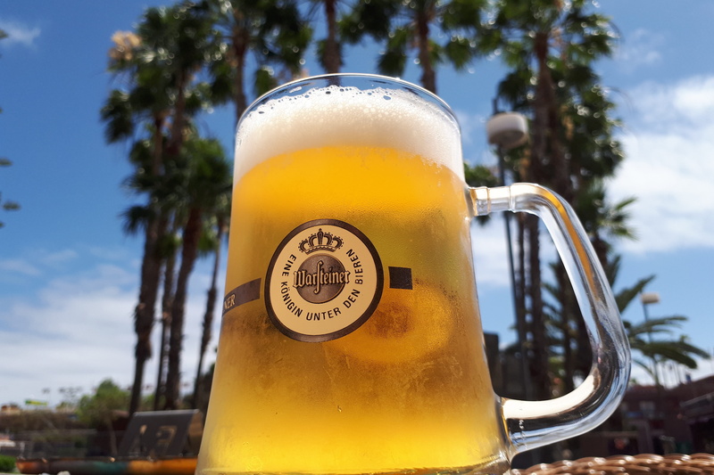 communication, palm trees, focus on foreground, day, western script, foam, text, alcohol, sky, beer, outdoors, refreshment, close-up, grancanaria, selective
