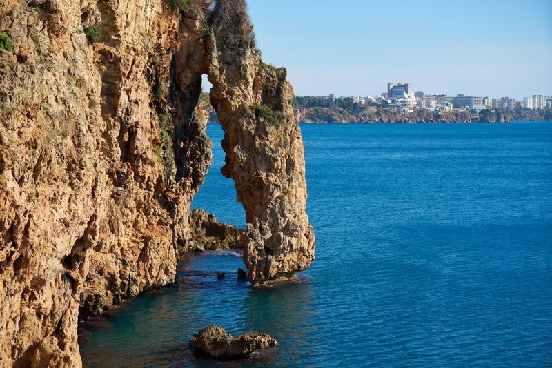 built structure, beauty in nature, open, day, rest, cliff, sky, solid, blue, color, wave, summer, outdoors, no people, rock - object, beach, marine, sea