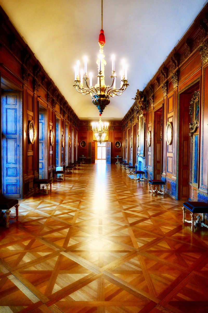 ceiling, hardwood, arcade, building, lamp, lighting equipment, built structure, empty, hall, light, luxury, wood, chandelier, tile, aisle, city, electric lamp