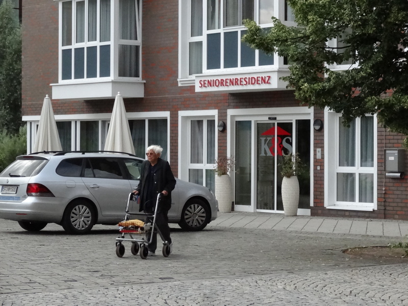 street, building exterior, land vehicle, seniors, text, day, full length, built structure, seniorin, car, men, woman, city, old peoples home, outdoors