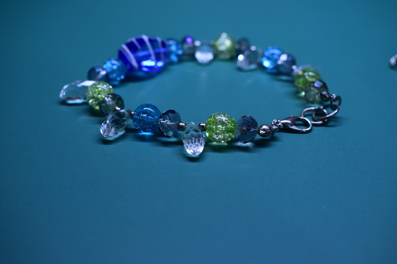 diamond - gemstone, fashion, silver colored, close-up, colored background, indoors, blue background, bracelet, turquoise colored, personal accessory, art