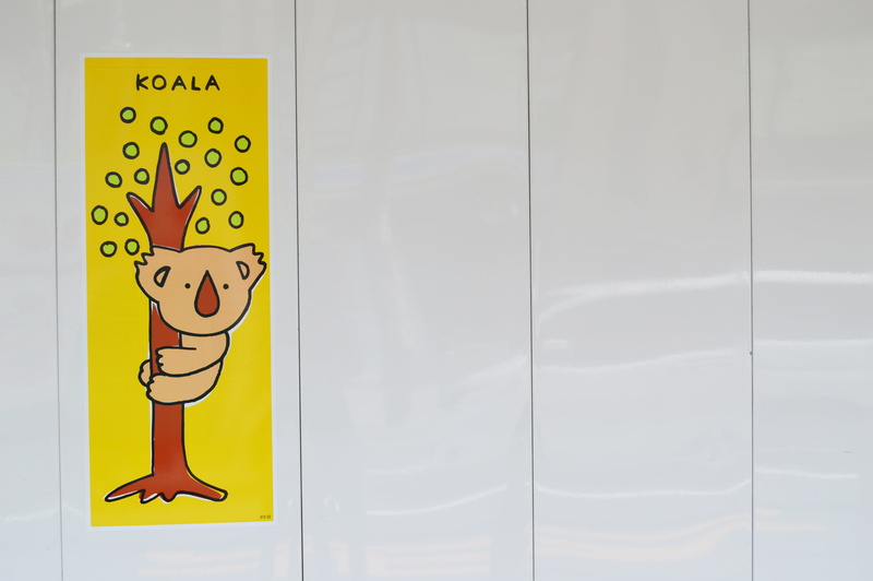 indoors, sign, wall - building feature, representation, warning sign, human representation, entrance, wall, cartoon, symbol, koala, sticker, close-up, yellow