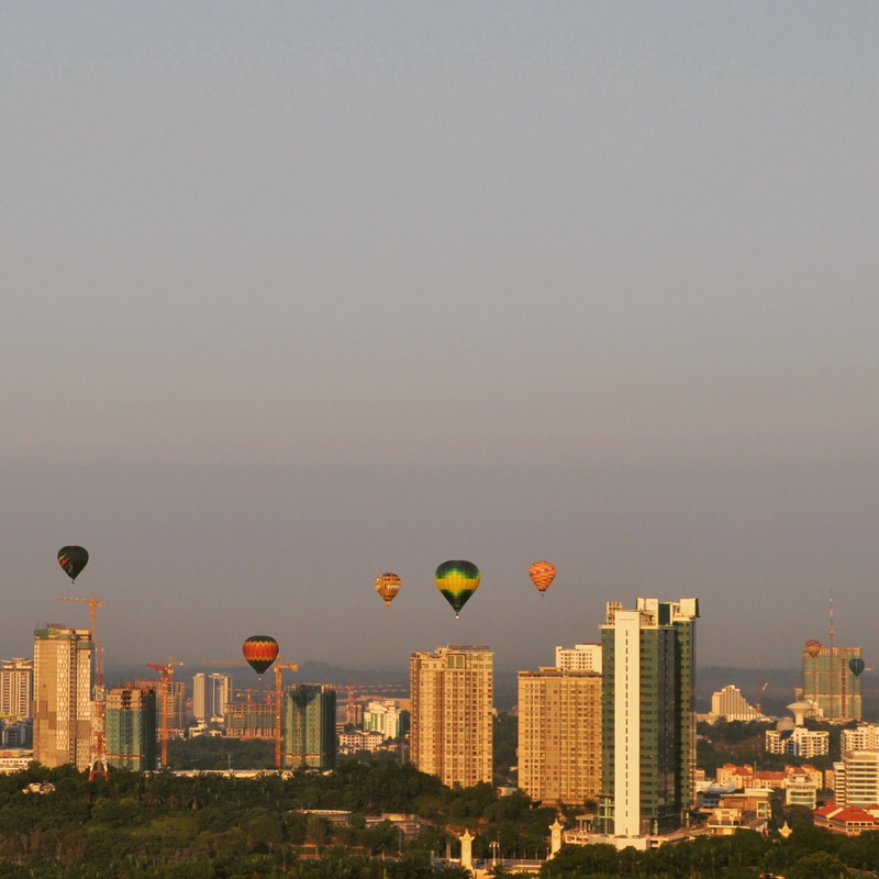 building, balloon, day, hot air balloon, building exterior, ballooning festival, mid-air, sky, air vehicle, cityscape, built structure, transportation
