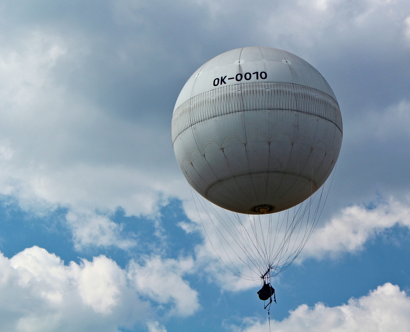 day, hot air, aerostat, text, clouds, flying, attraction, cloud - sky, leisure activity, nature, parachute, balloon, transportation, low angle view, sport