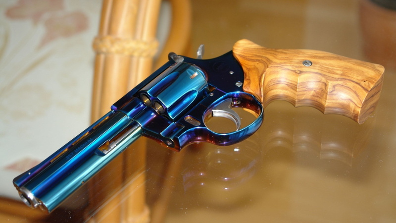 1080P, wood - material, bullet, close-up, still life, sign, single object, table, indoors, focus on foreground, no people, gun, violence, aggression, ammunition