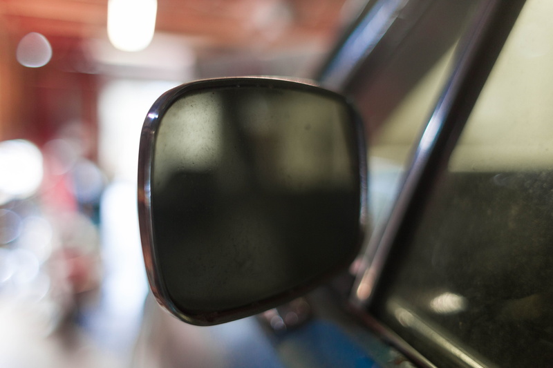 car mirror, transportation, appliance, hardware, vehicle mirror, boardwalk, mirror, focus on foreground, one person, side-view mirror, outdoors, hook, mouse