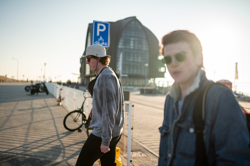incidental people, apparel, human, bike, bridge, daytime, boardwalk, people, two people, sports, focus on foreground, young men, nature, sky, city, outdoors