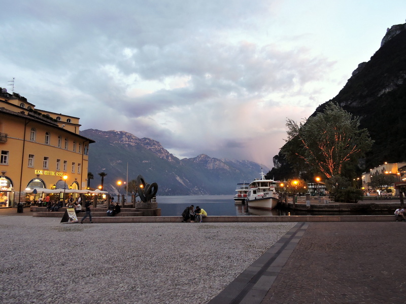 architecture, mode of transportation, clouds, building exterior, mountain range, riva del garda, europe, nature, twilight, light, sunset, outdoors, european Alps
