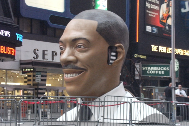 2K, times square, travel, male likeness, smiling, outdoors, human face, communication, new york, eddie murphy, human representation, close-up, portrait