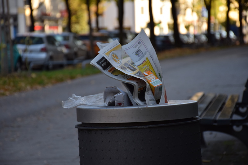 close-up, newspaper, waste bins, footpath, street, currency, mode of transportation, dustbin, focus on foreground, waste container, sidewalk, paper, 5K