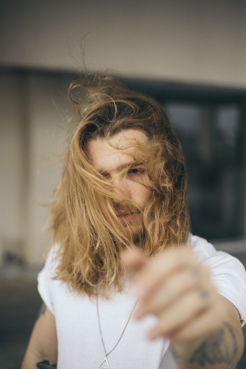 focus on foreground, hair, model, emotion, women, blur, depth of field, one person, handsome, sad, 4K, photoshoot, sadness, real people, long hair, person