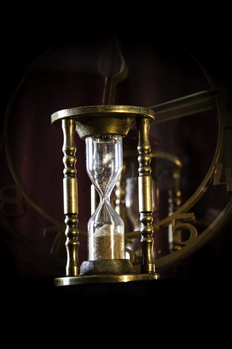 black background, still life, deadline, glass - material, time, gray, sand, egg timer, hourglass, close-up, timer, no people, table, clock face, indoors