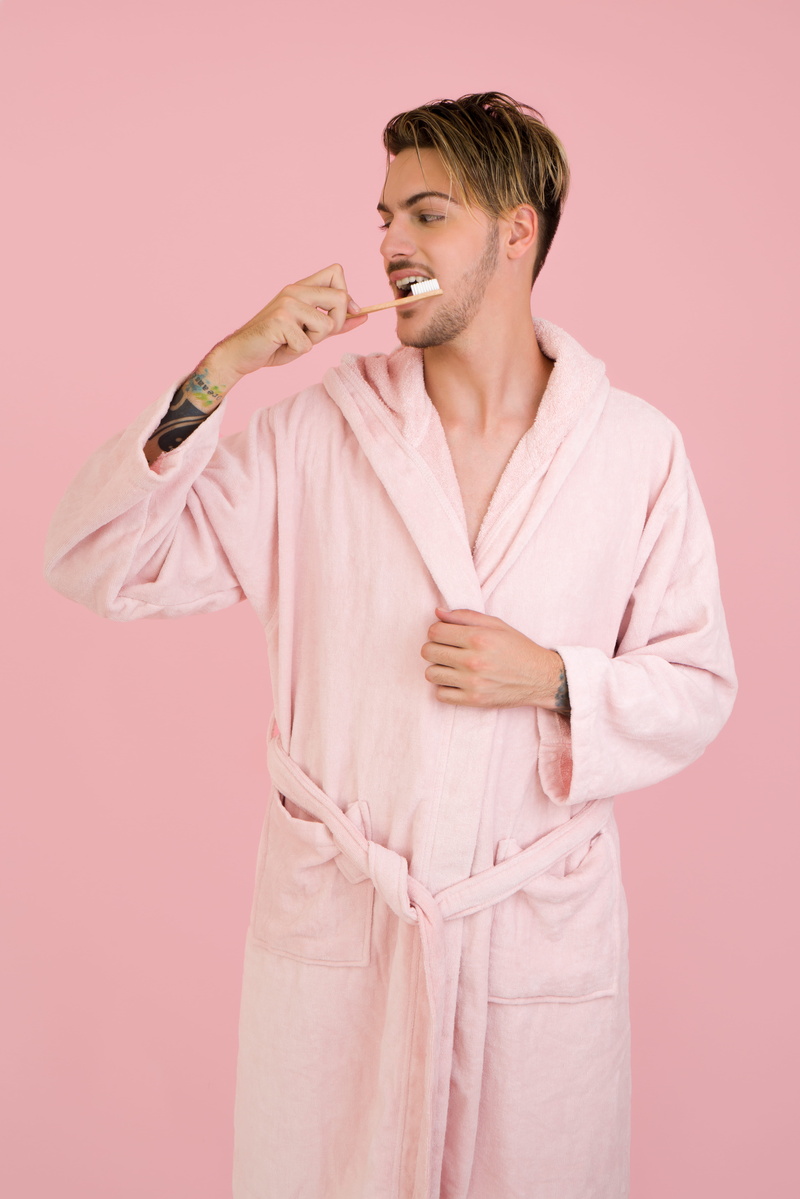 holding, indoors, waist up, pink, front view, brushing teeth, one person, adult, happiness, colored background, 8K, robe, men, pink background, man, bathrobe