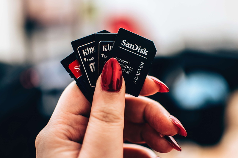 personal perspective, opportunity, memor cards, focus on foreground, text, photography, unrecognizable person, nails, close-up, 4K, holding, person, blur
