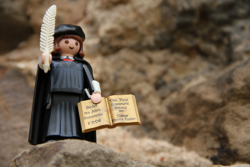human representation, rock, outdoors, black, wearing, focus, woman, bible, book, costume, feather, pen, multicolored, Reformation, Luther, childhood, selective