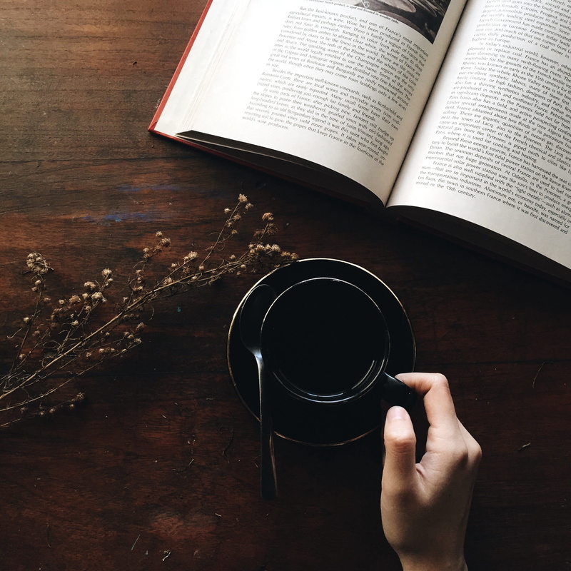 morning, cup of coffee, holding, cup, publication, lifestyles, book, hand, finger, human body part, table, black, cut, tea, mug, open book, one person