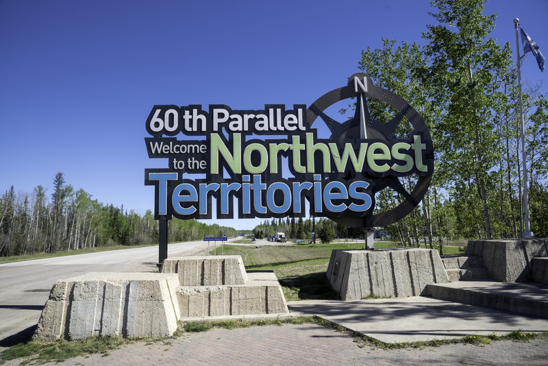 clear sky, sunlight, tree, welcoming, no people, communication, capital letter, sky, information, outdoors, text, road sign, plant, blue sky, uSA, Northwest Territories