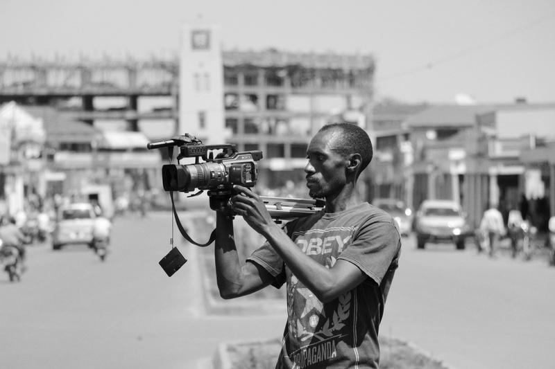 shooting, camera - photographic equipment, holding, digital single-lens reflex camera, technology, uganda, one person, occupation, casual clothing, photographer