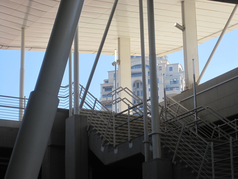 office building exterior, clear sky, architecture, uprights, low angle view, day, building, sky, outdoors, roof, diagonals, stairs, no people, city, poles