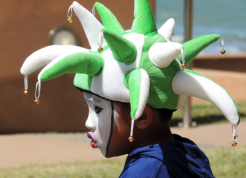 hat, focus on foreground, carnival, close-up, real people, mask, childhood, standing, green color, outdoors, paint, jester, colour, disguise, young, fun