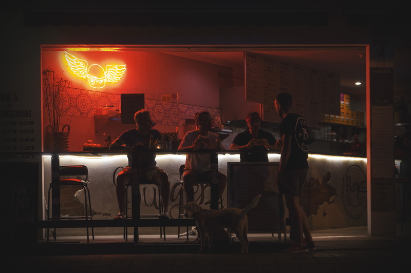 real people, illuminated, lighting equipment, outdoors, 5K, medium group of people, burgers, transportation, neon, eating, group, dog, sitting, Marvin Meyer