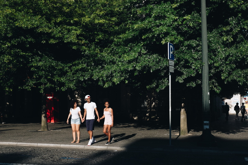 men, walking, siblings, real people, signage, street, trees, action, adult, crossing, plant, wear, women, people, tree, sisters, standing, two, casual clothing