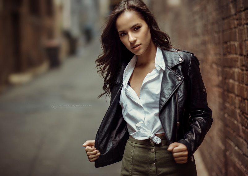 alleyway, open clothes, 1080P, looking at viewer, wavy hair, city, brunette, long hair, shirt, open mouth, outdoors, holding clothes, bricks, women, Julien Fischer