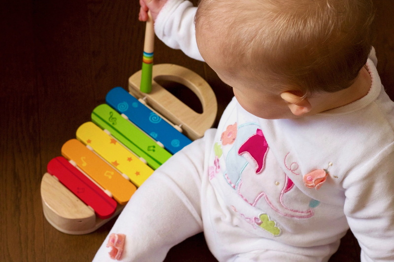 holding, baby clothing, sitting, young, xylophone, toy, close-up, multicolored, childhood, playing, lifestyles, high angle view, one person, multi colored