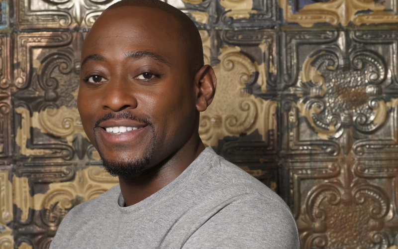 one person, front view, close-up, architecture, portrait, leisure activity, ornate, happiness, casual clothing, omar epps, young adult, young men, smiling