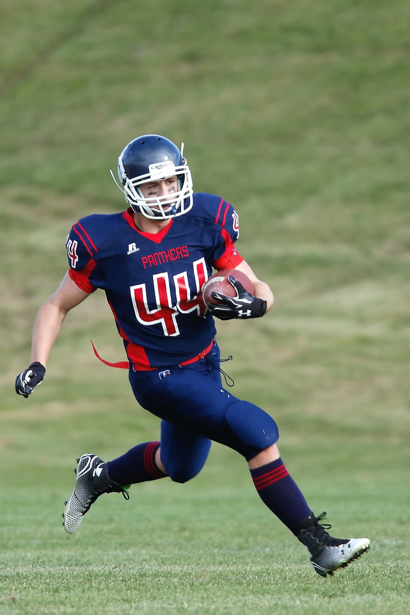 headwear, american football field, sports uniform, competing, pigskin, full length, canada, ball, ball carrier, effort, athlete, game, grass field, running