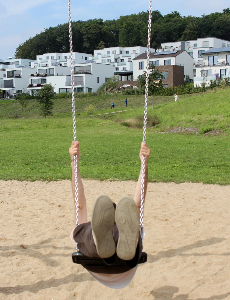 enjoyment, built structure, grass, plant, land, outdoor play equipment, chain, building, day, sunlight, outdoors, childrens playground, shoes, nature, playground