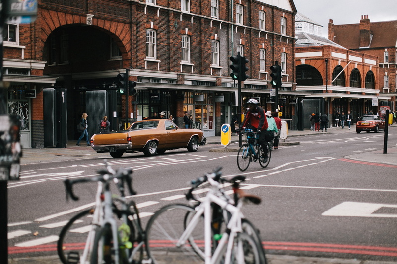 people, travel, architecture, sport, transportation, action, car, daylight, wheels, pavement, brown, motor vehicle, traffic, road marking, buildings, traffic lights