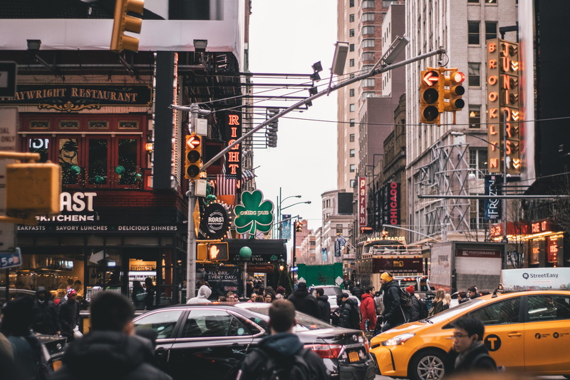 market, tourism, group, cars, stores, motor vehicle, city, public, shops, yellow taxi, buildings, signage, traffic lights, business, road, taxi, pavement