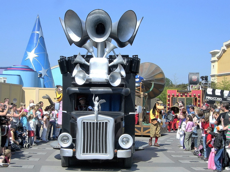 sunlight, street, disney, travel, parade, large group of people, crowd, road, city, sky, day, real people, nature, megaphone, transportation, land vehicle