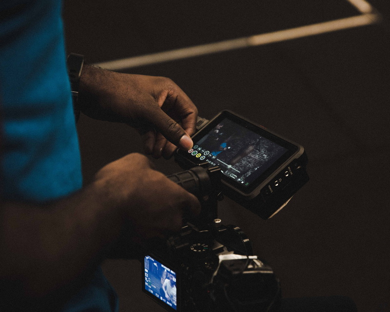 photography themes, video camera, occupation, flooring, connection, one person, camera, digital camera, communication, wood, screen, working, hand, human body part