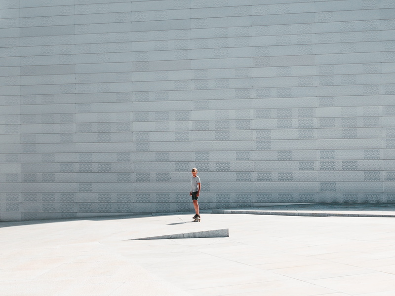 one person, wall, human, man, skateboard, standing, floor, working out, outdoors, sports, side view, flooring, adult, exercise, building exterior, person