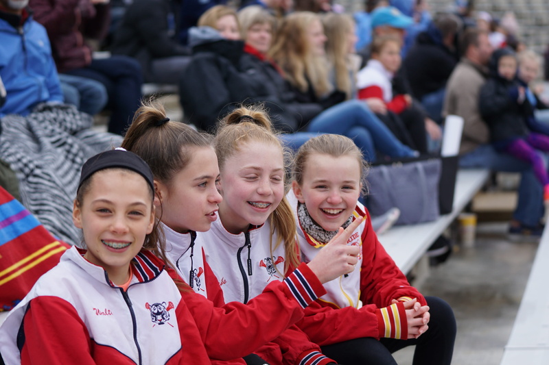 sitting, audience, portrait, smiling, crowd, leisure activities, finger, men, uniform, 5K, offspring, girls, focus on foreground, trademark, clothing