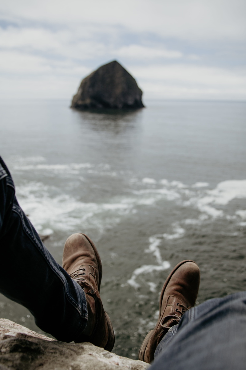 low section, land, bokeh, hang, rock, boot, adventure, human limb, day, person, human body part, sky, feet, personal perspective, one person, water, human leg