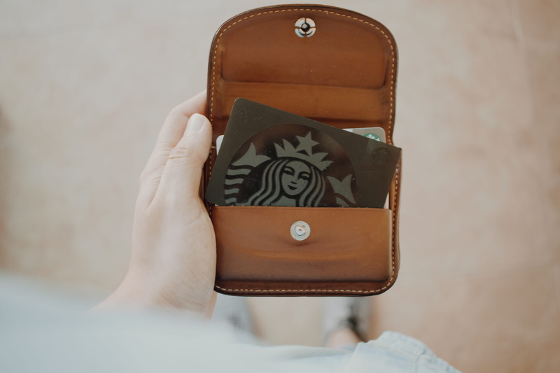 coffee, indoors, human hand, franchise, box - container, starbuck, person, loyalty card, card, women, tarjetum, focus on foreground, gift box, inside, jewelry box