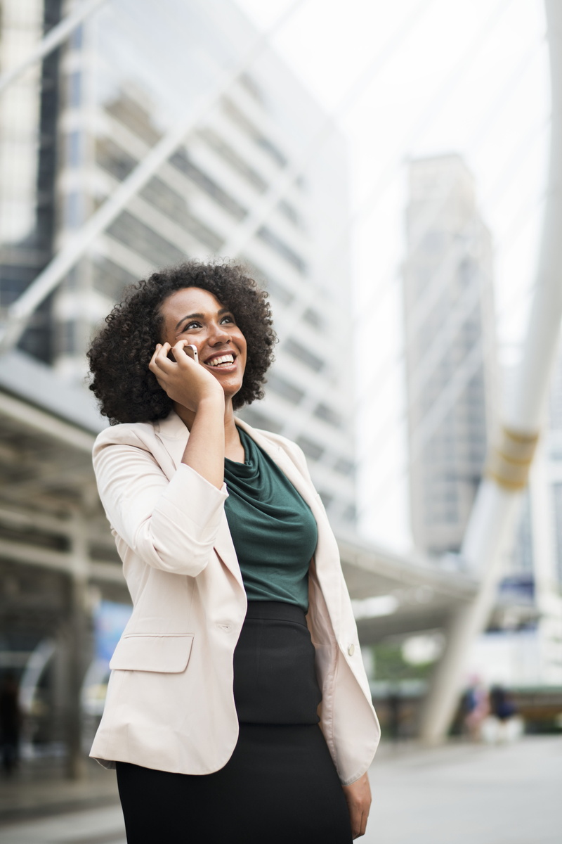business person, standing, answering, focus on foreground, young women, chongnonsi, well-dressed, communication, outdoors, built structure, hairstyle, smiling
